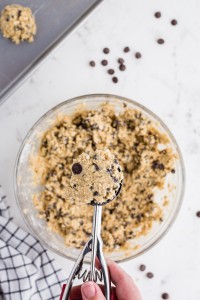 ice cream scoop in glass bowl with Oatmeal Chocolate Chip Cookie dough on marble countertop
