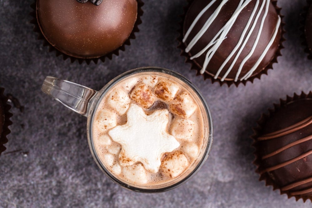 top shot of hot chocolate bomb that has opened in a glass mugs with marshmallows