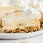 close up of banana cheesecake with a whipped cream topping