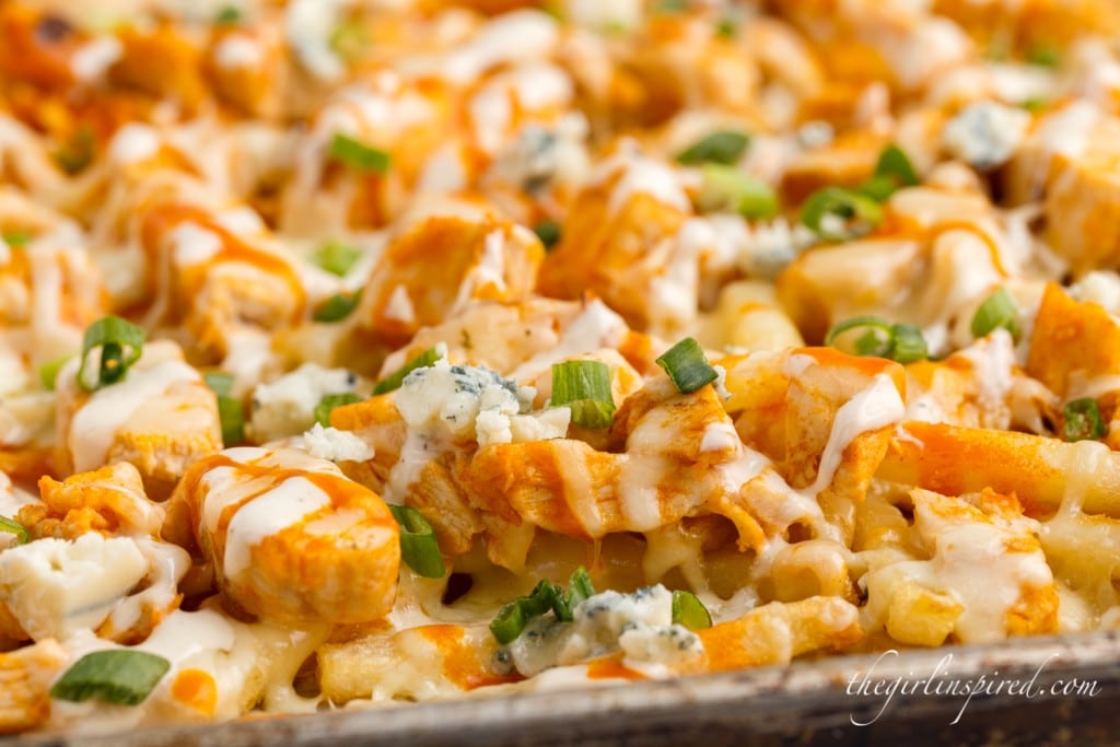 crispy fries with buffalo chicken bites topped with melted cheese and green onions