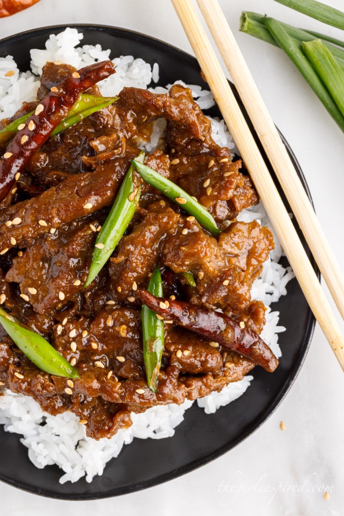 instant pot mongolian beef served on a bed of white rice next to chopsticks