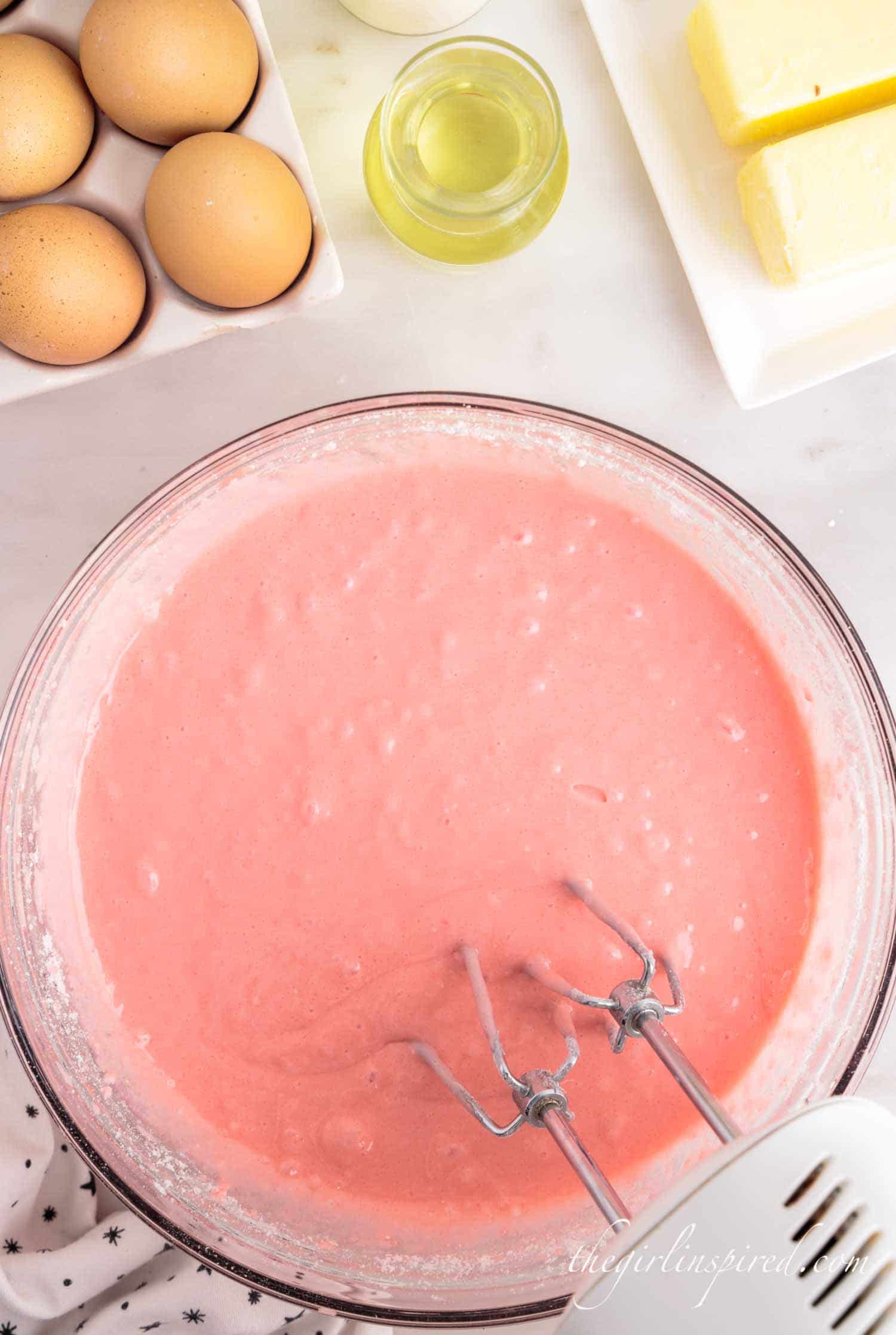 Pink cake mix in a bowl combined with wet ingredients
