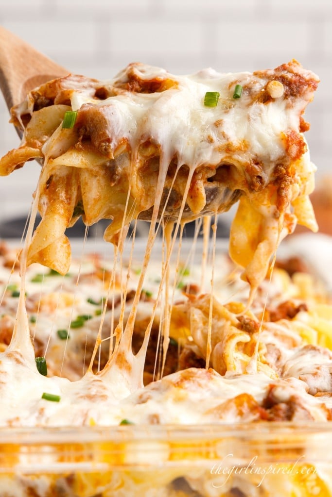 a scoop of sour cream noodle bake with sprinkled green onions on top