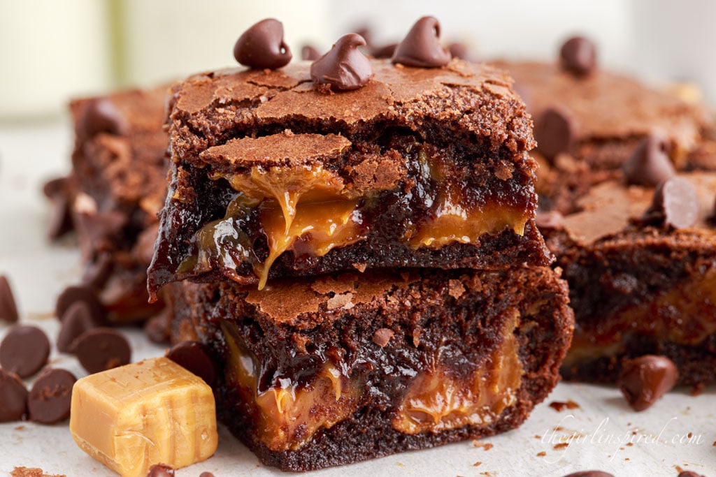 caramel brownies topped with chocolate chips next to caramel candy