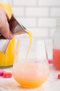 Glass with Starburst candy alcohol and ice with juice and soda being added