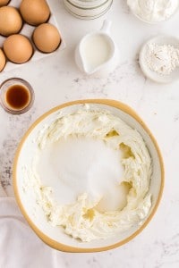 sugar added to the beaten cream cheese with other ingredients surrounding