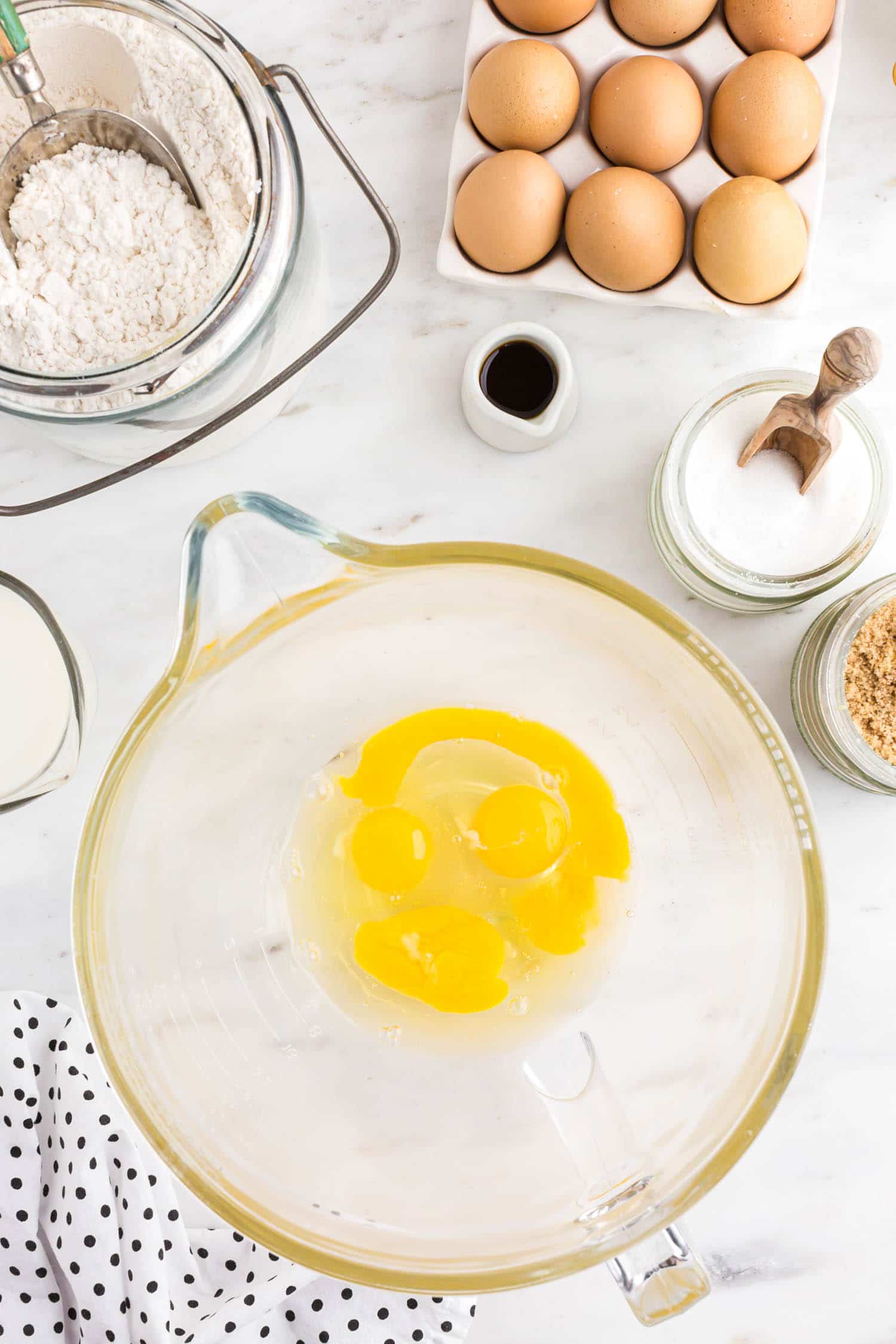 eggs in mixing bowl with other ingredients around.