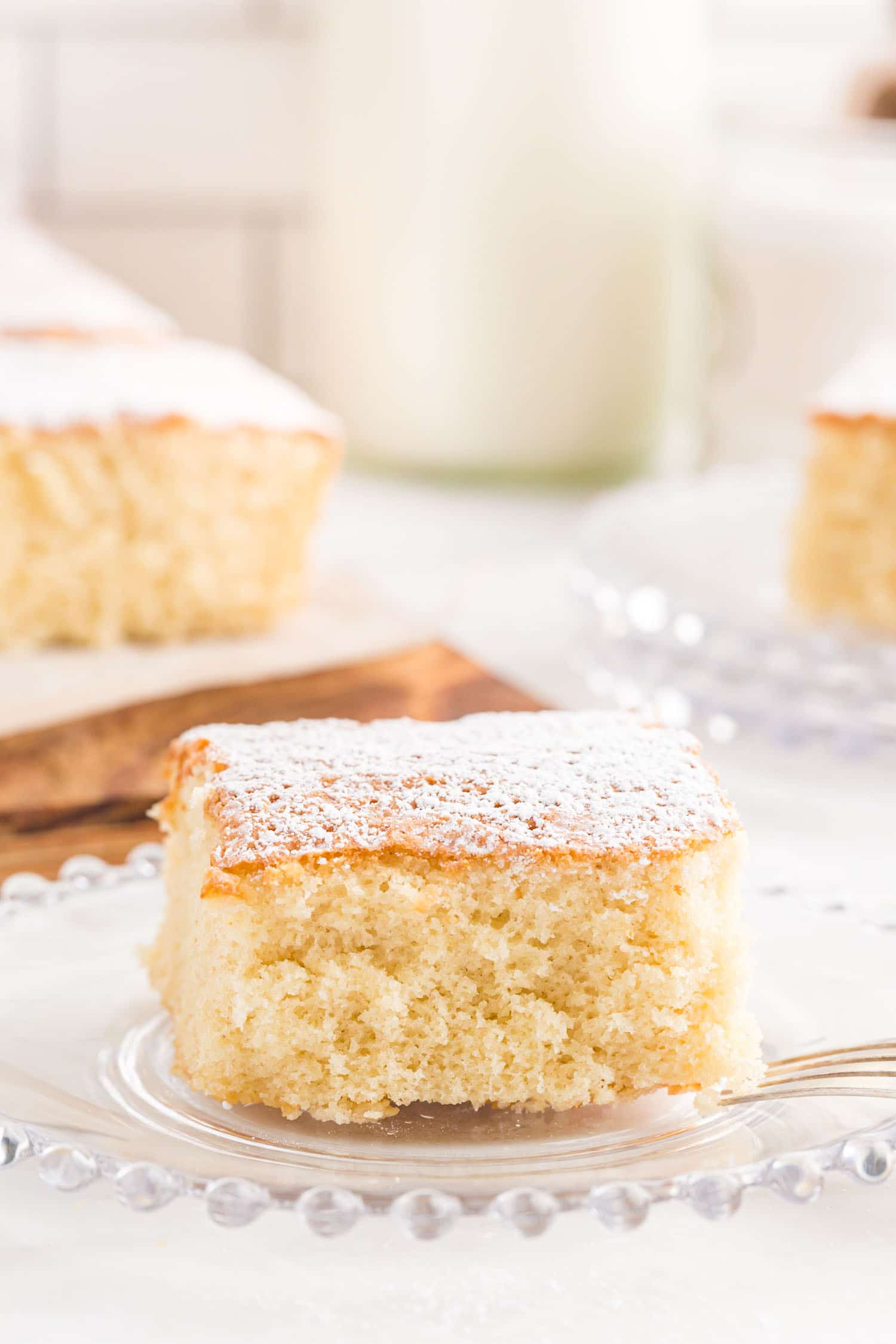 slice of milk cake on glass serving plate.