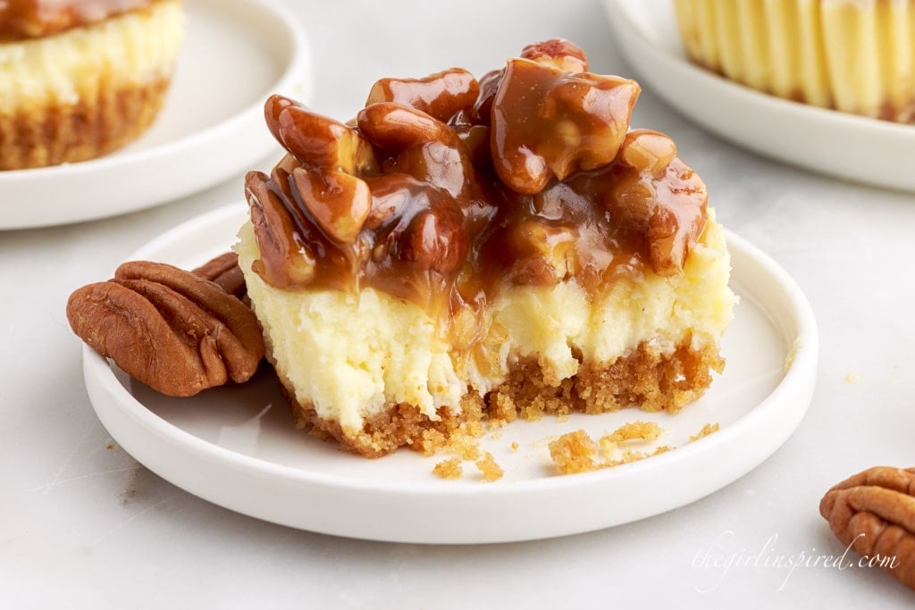 a mini pecan cheesecake on a small plate with a bite taken out