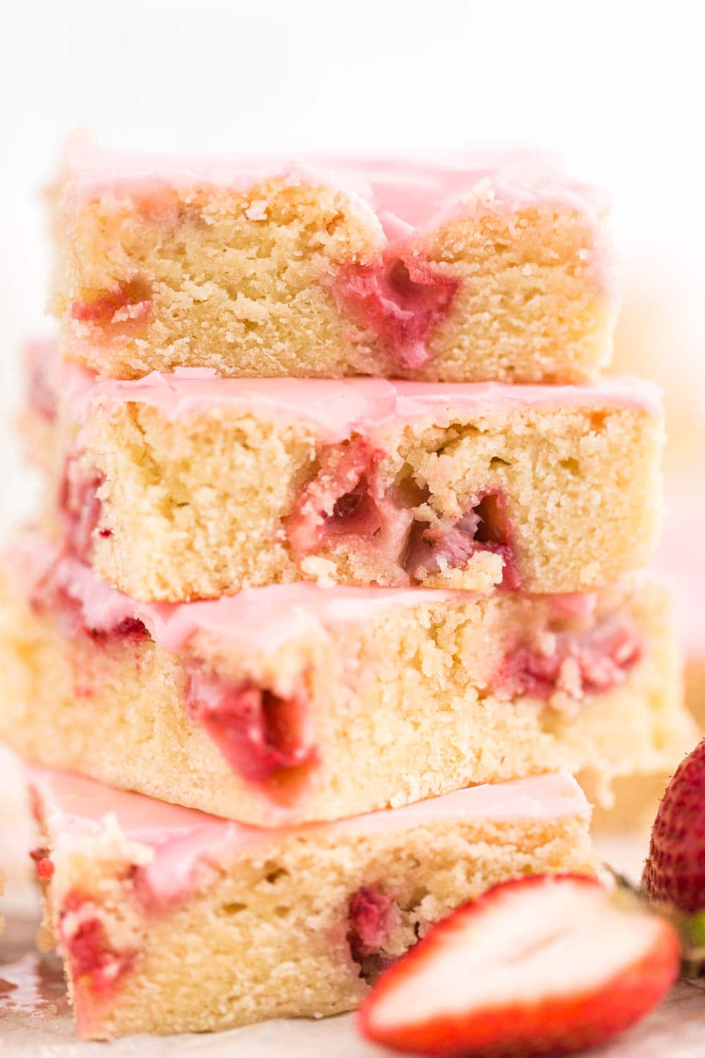 Four pieces of Strawberry Lemon Blondie piled up on top of each other, strawberry in front