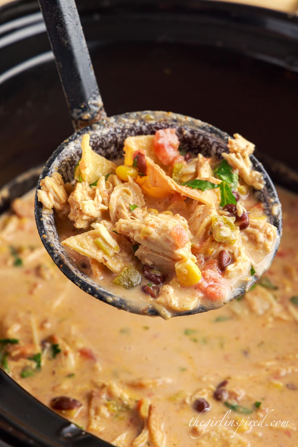 a ladle of tortilla chicken soup over the crock pot