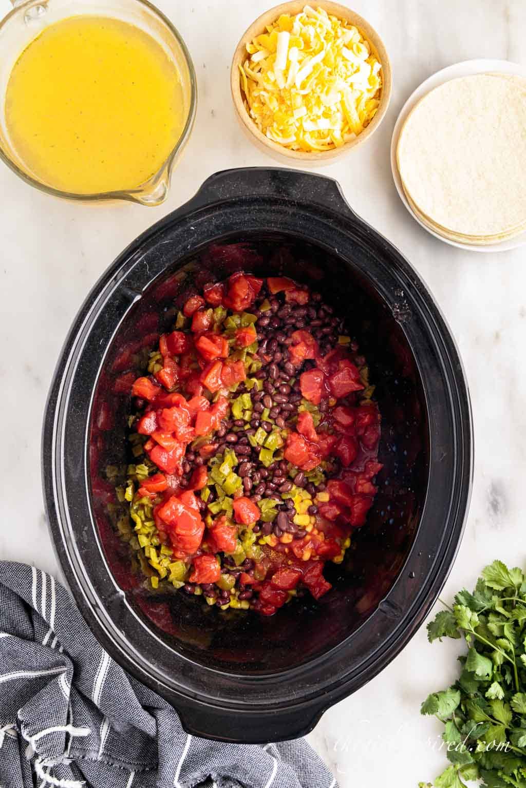tomatoes, chiles, black beans layered in the crockpot.