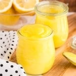 lemon curd in small glass jars on wooden cutting board with polka dot linen