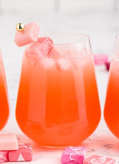 stemless wine glasses filled with pink cocktail and ice with pink starburst skewered and placed in glass