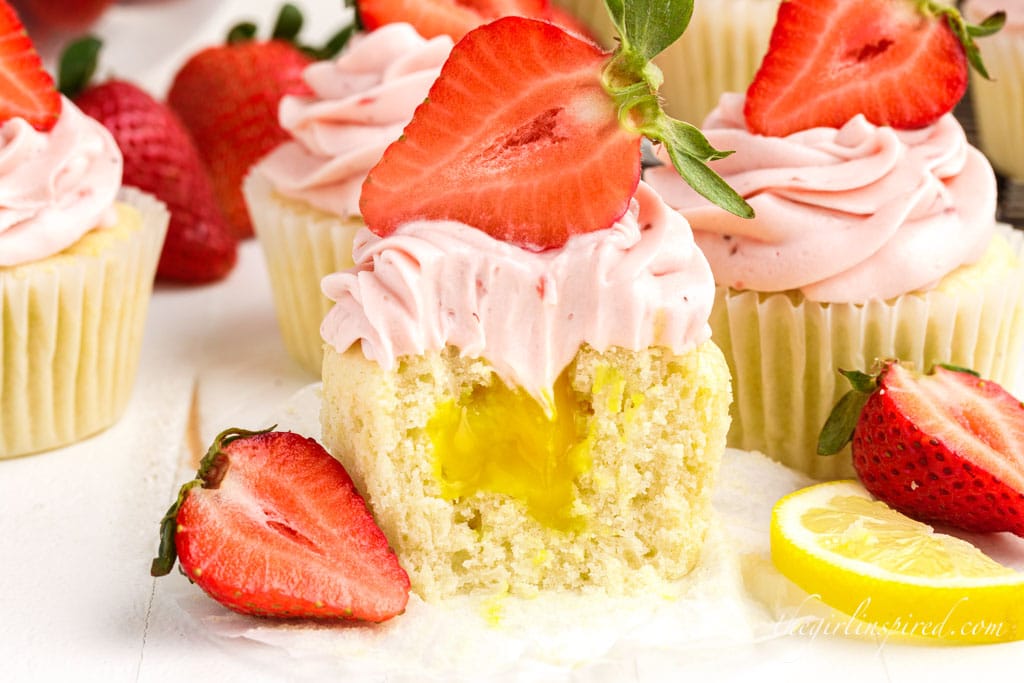 strawberry lemon cupcake with a bite taken out showing the lemon curd inside