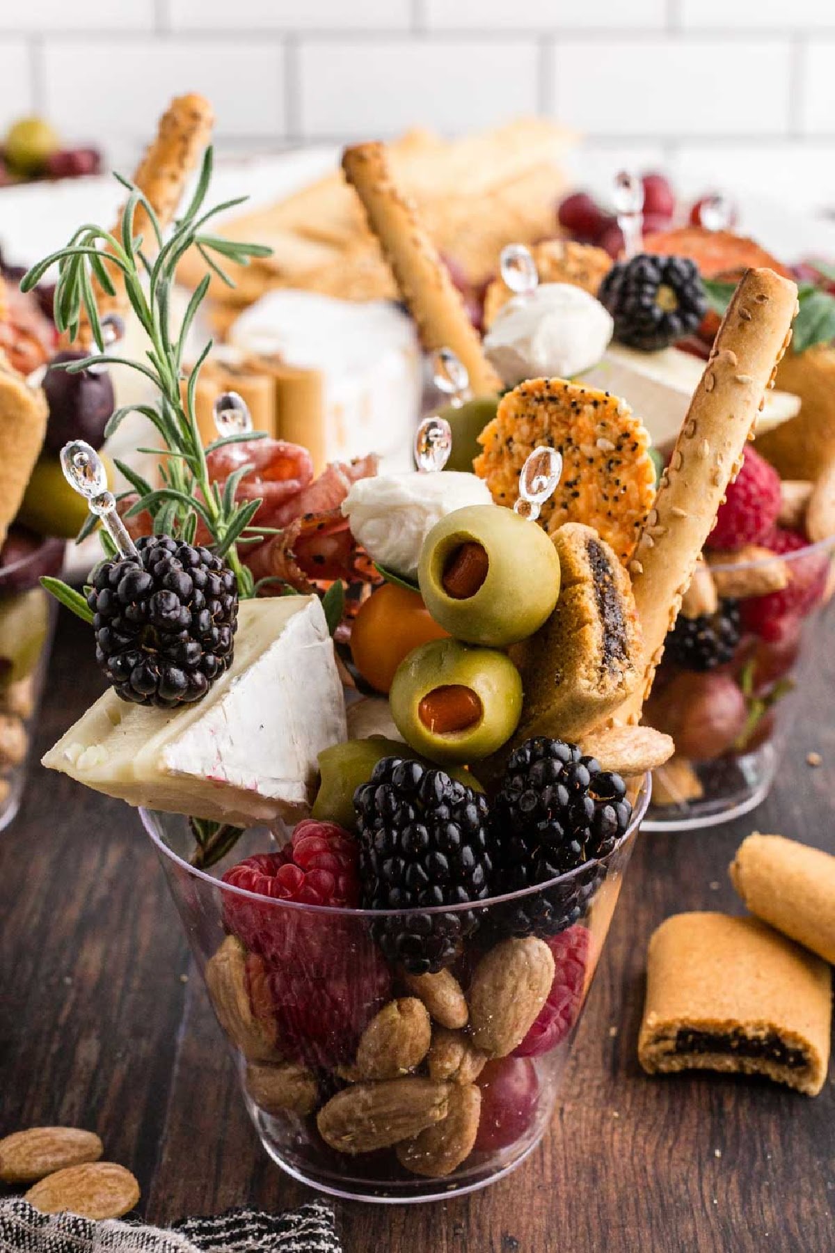 Fully assembled charcuterie cups stuffed full of bite-sized fruit, cheese, cookies, and nuts.