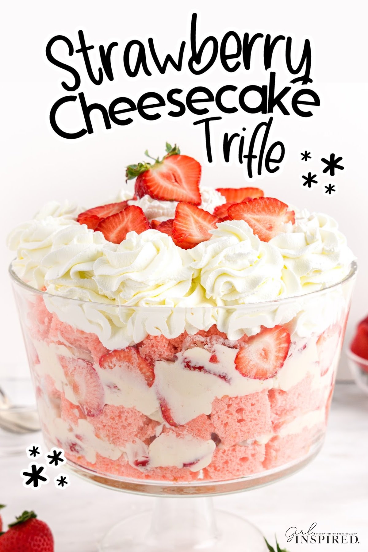 Layers of strawberry cake and whipped cream, fresh strawberries, and text title "Strawberry Cheesecake Trifle."