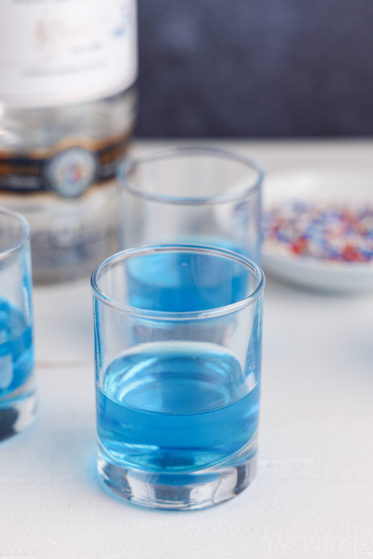 Several shot glasses filled ⅓ of the way with blue jello.