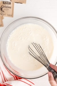 white mixture in glass bowl with whisk