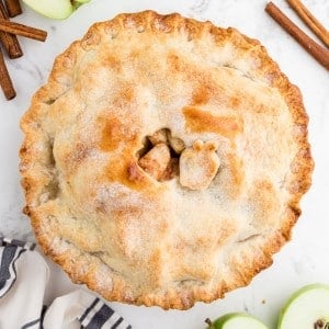 top butter pie crust of an apple pie with a heart cutout and sprinkled with sugar