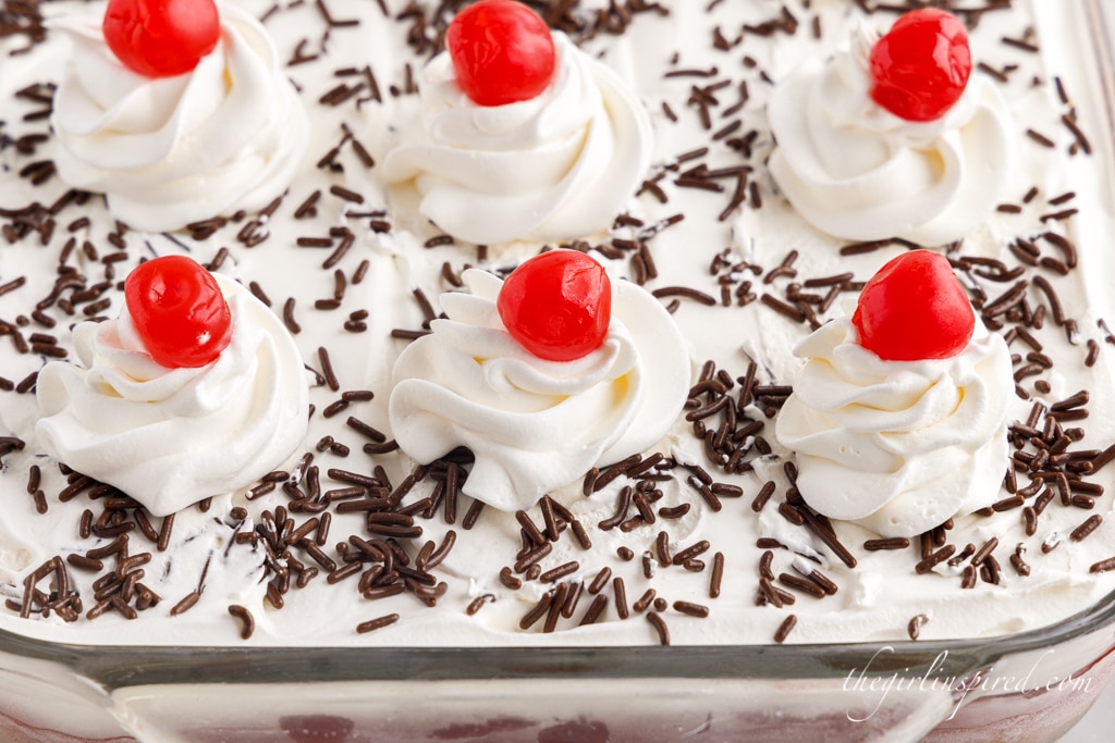 chocolate cherry lush in a glass baking dish topped with whipped cream and cherries