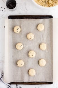 cookie dough balls flattened slightly on cookie sheet.