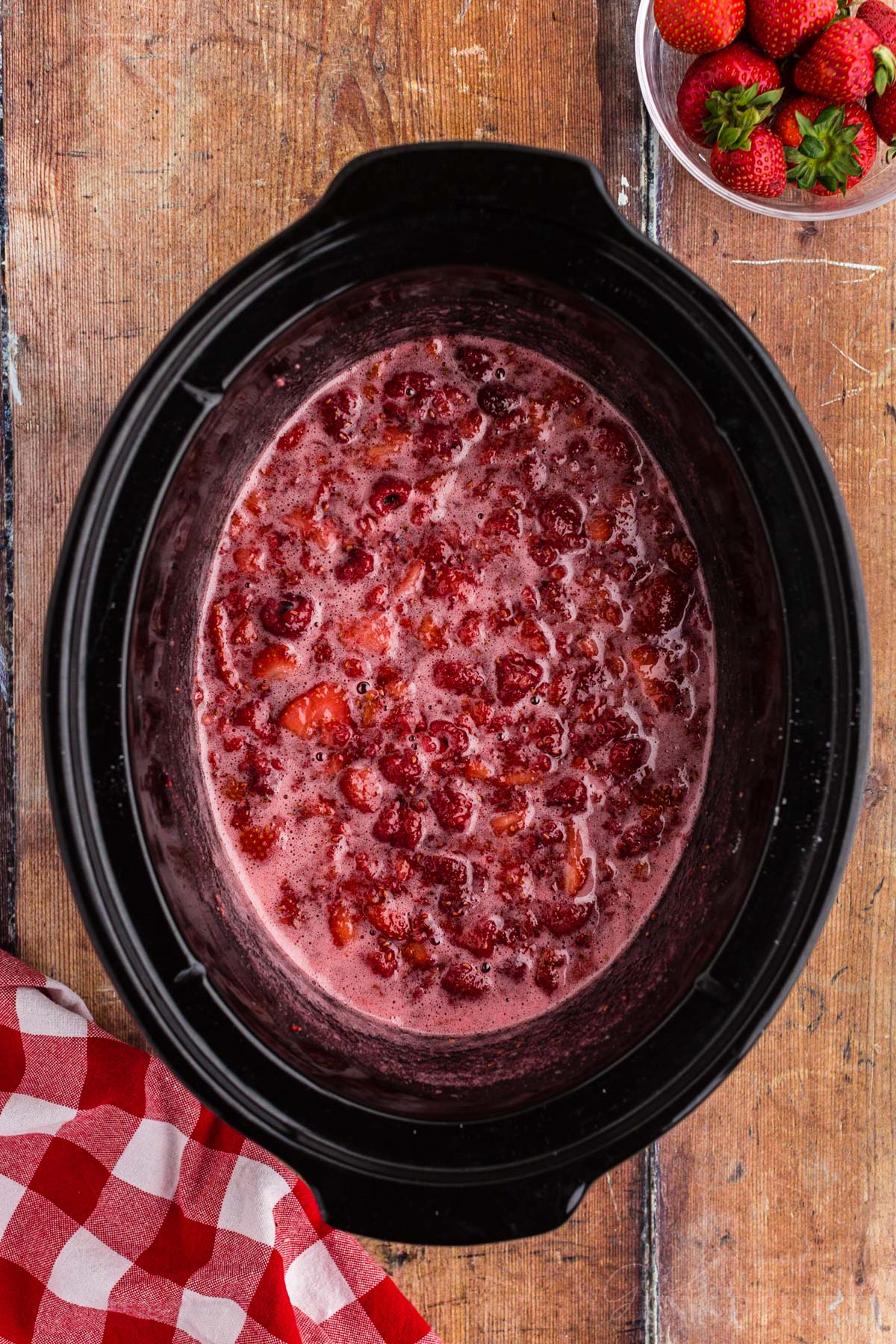 Strawberry raspberry jam cooked and bubbly in a crockpot.