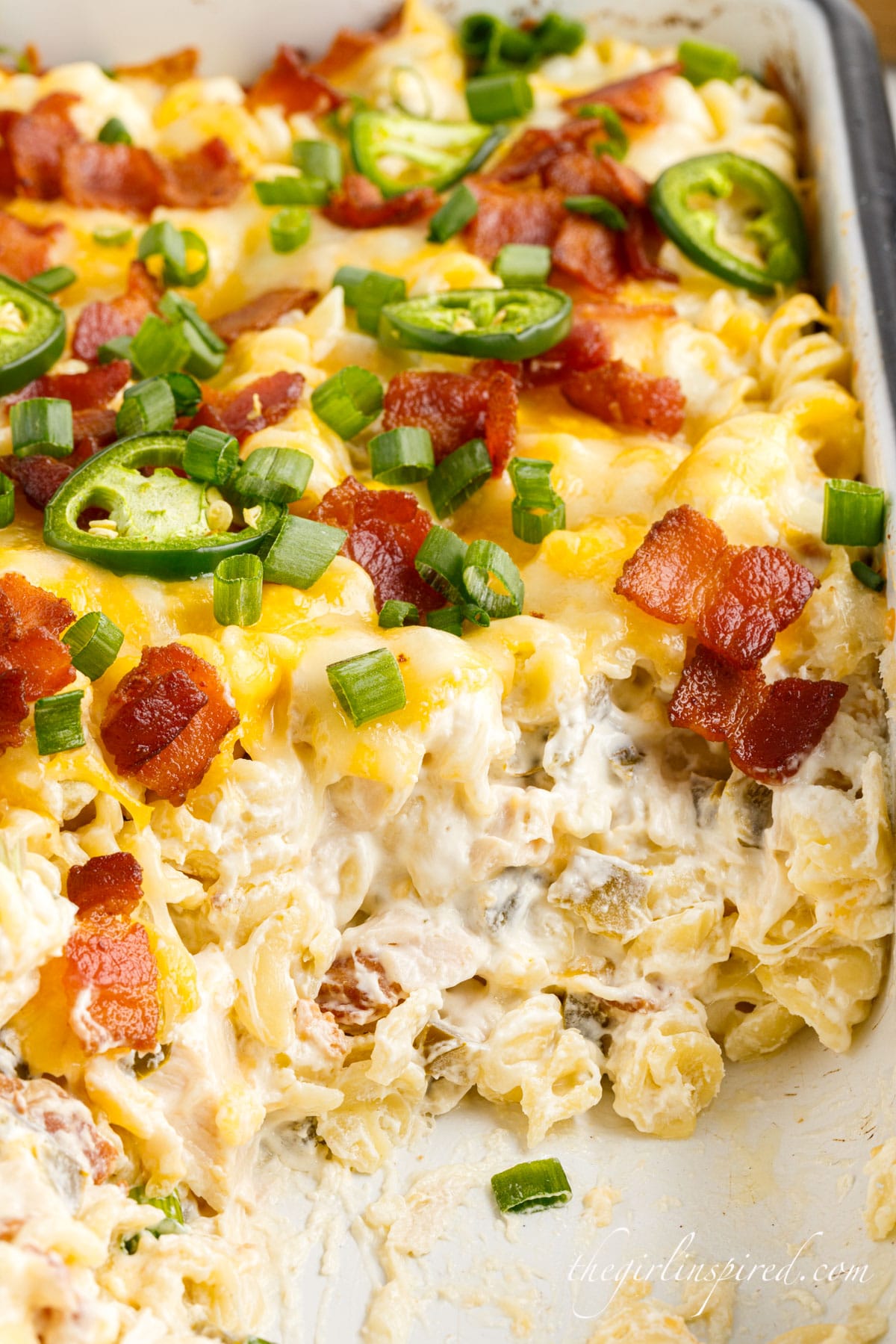 Jalapeno Popper Chicken Casserole in a dish with a scoop taken out