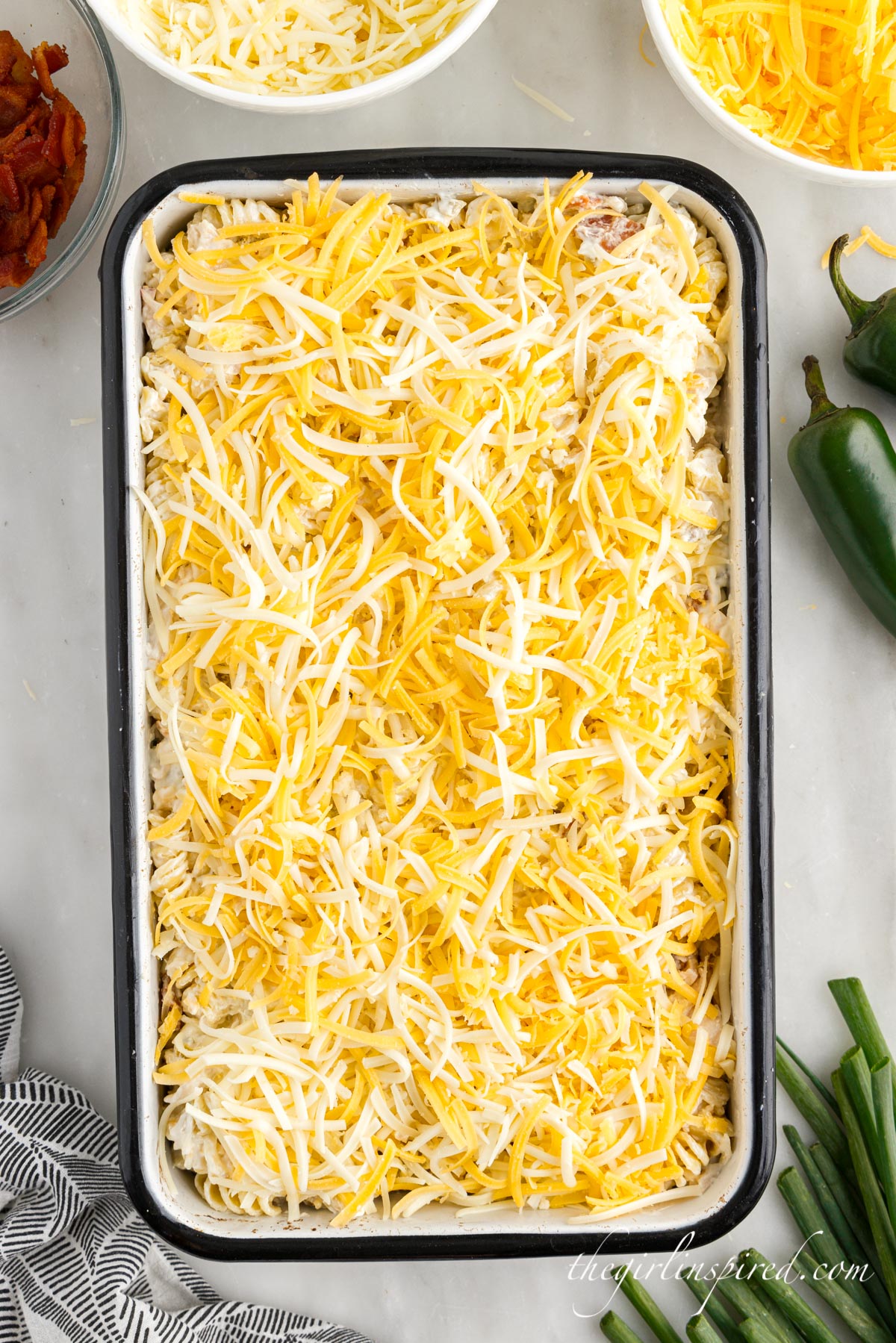 Jalapeno Popper Chicken Casserole topped with cheese before baking