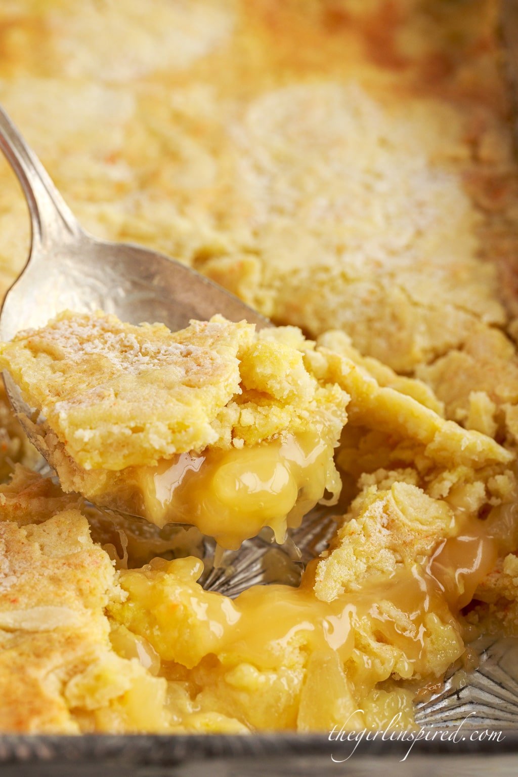 close up of a big spoon scooping out lemon pineapple dump cake