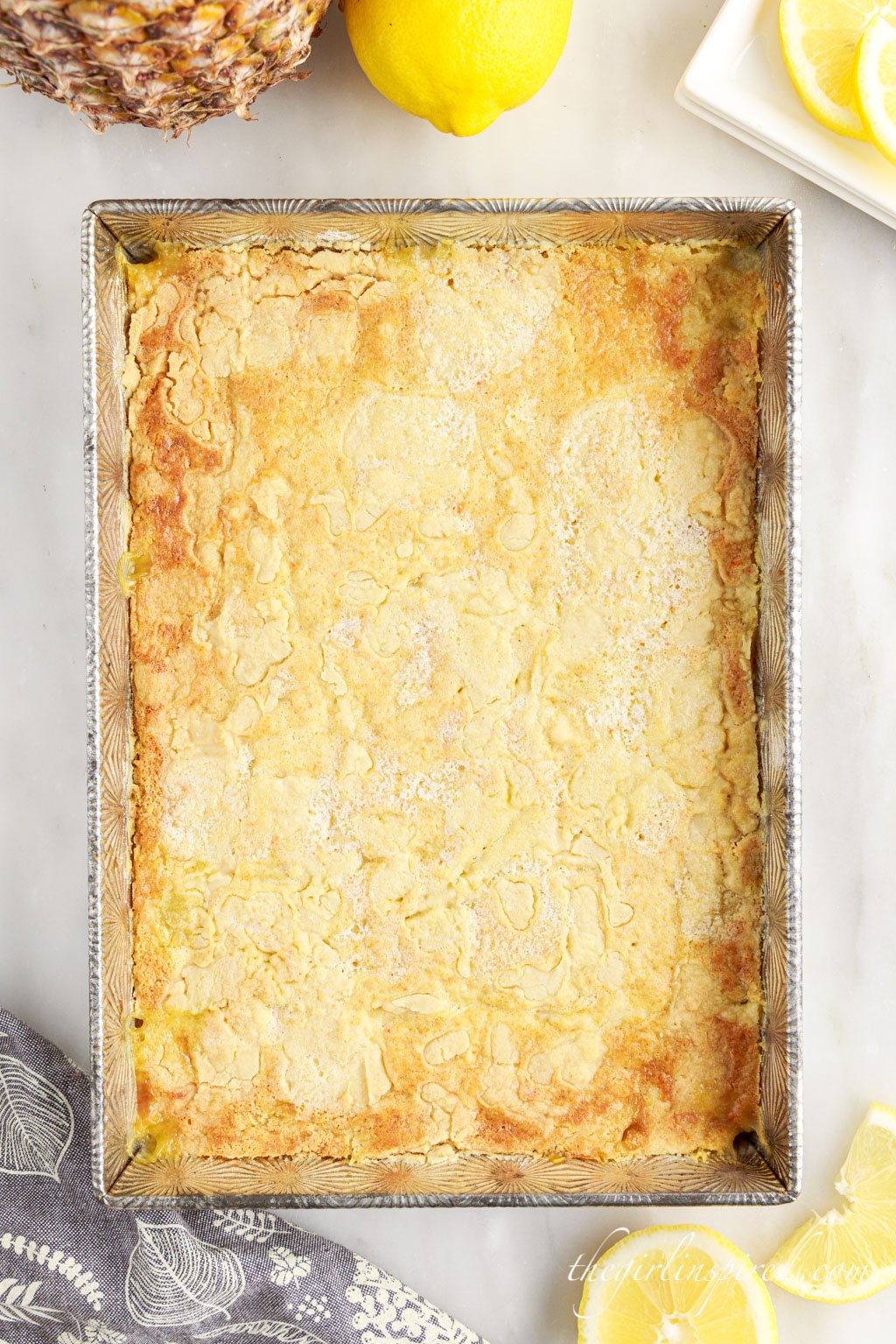 Top view of the baked lemon pineapple dump cake in a silver baking pan.
