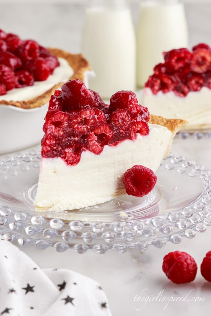 several slices of raspberry cream cheese pie slices on glass plates