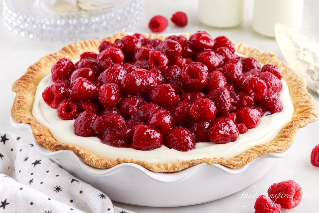 a raspberry cream cheese pie topped with fresh raspberries 