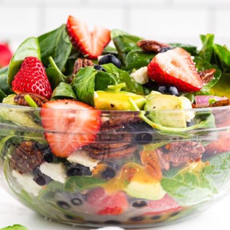 strawberry feta spinach salad in glass bowl.