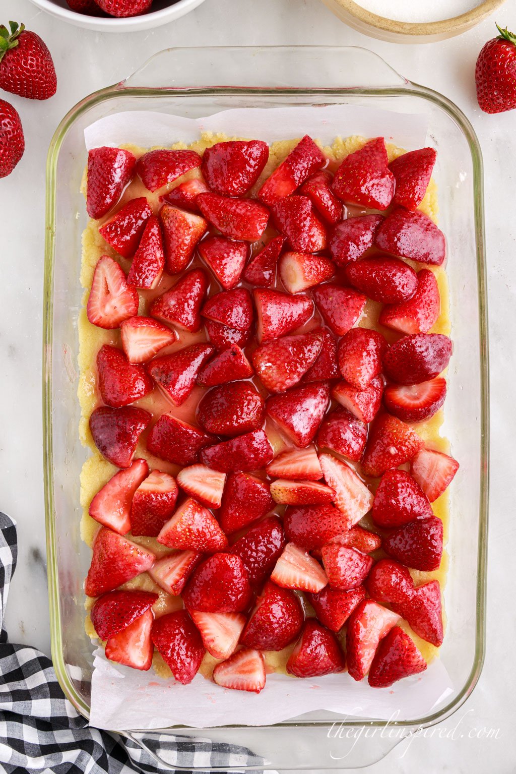 strawberry filling layer on top of shortbread crust in a glass baking dish