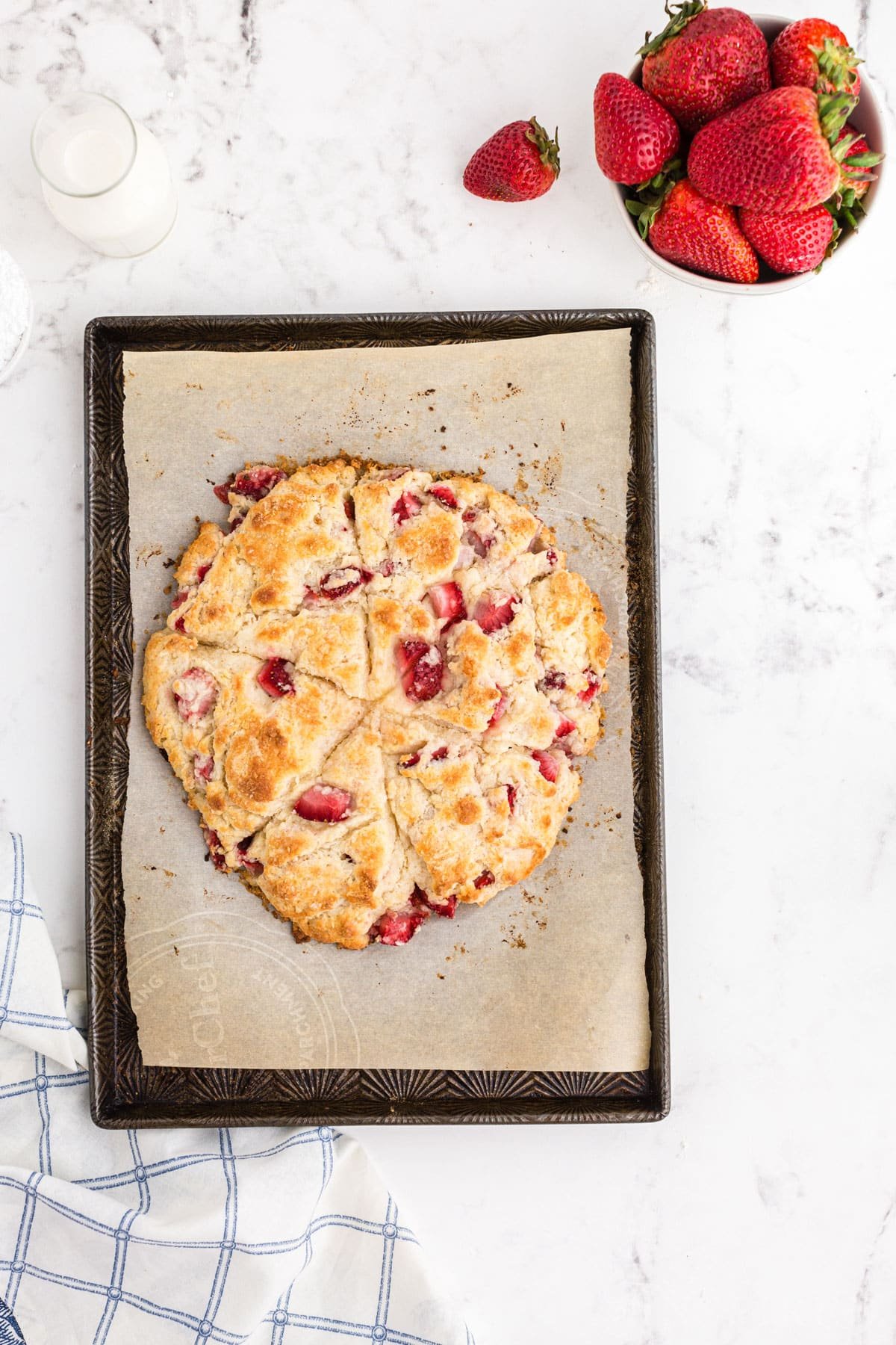 Baked strawberry scones on baking sheet.