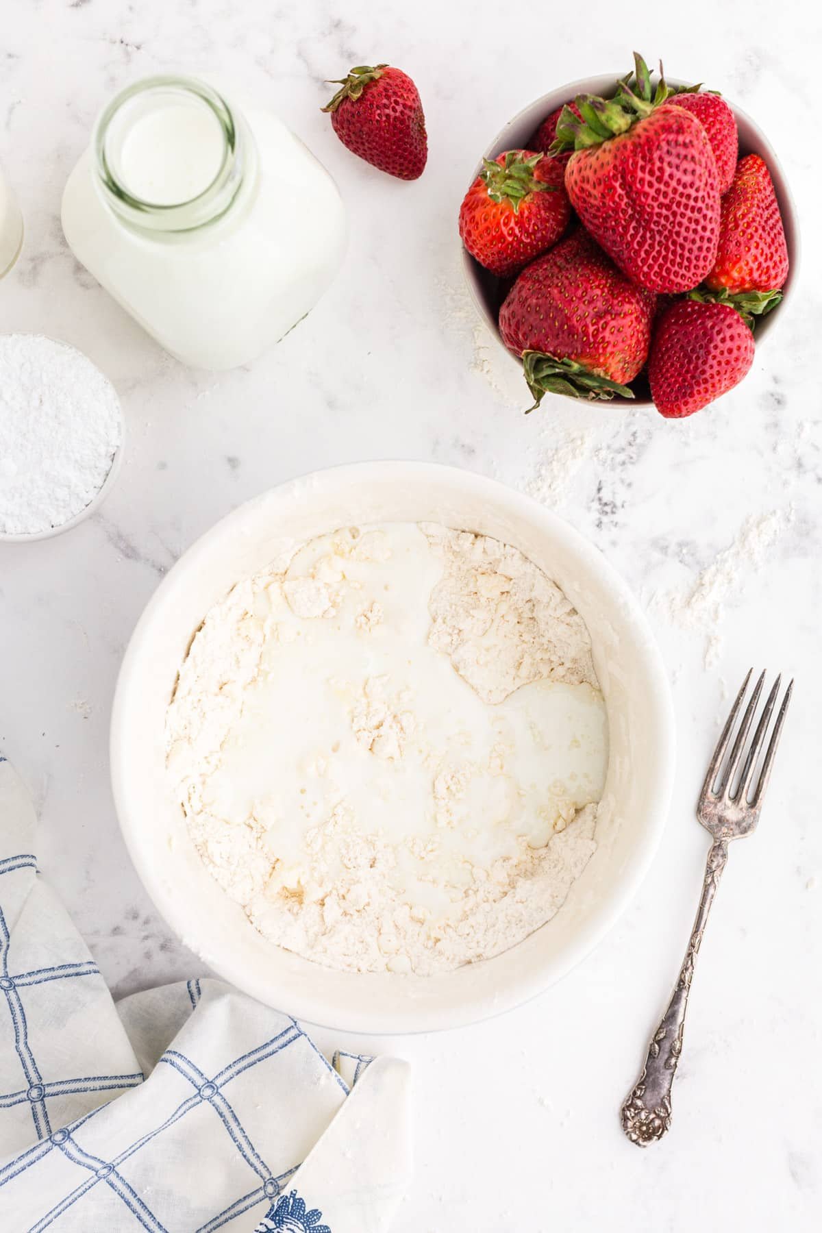 Milk poured over scone ingredients in mixing bowl.