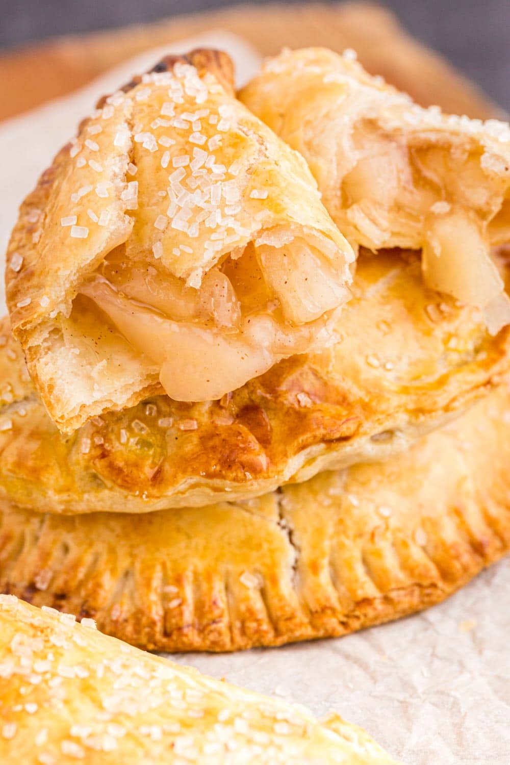 Two stacked apple hand pies, top apple hand pie open with filling exposed.
