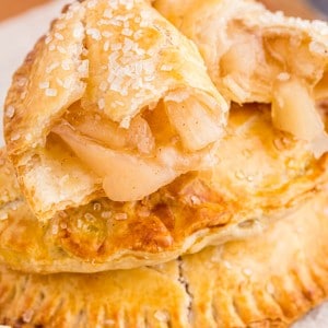 Two stacked apple hand pies, top apple hand pie open with filling exposed