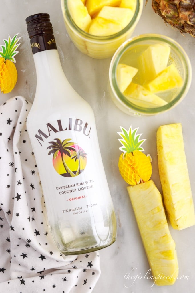 top view of pineapple spears and bottle of malibu rum