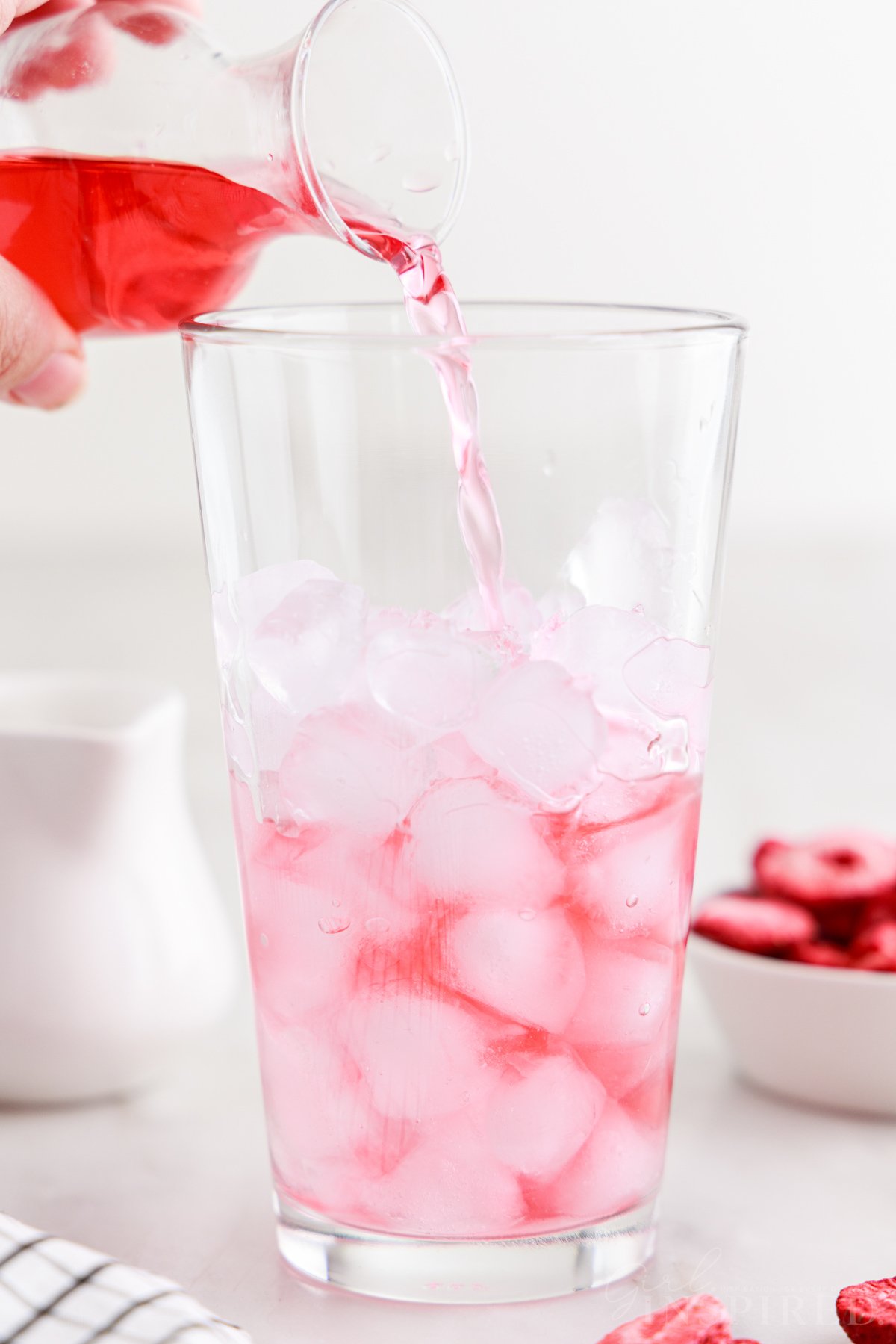 Dark pink tea-infused juice poured into a glass of ice.