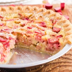 Rhubarb custard pie with slice removed showing the thick custard inside.