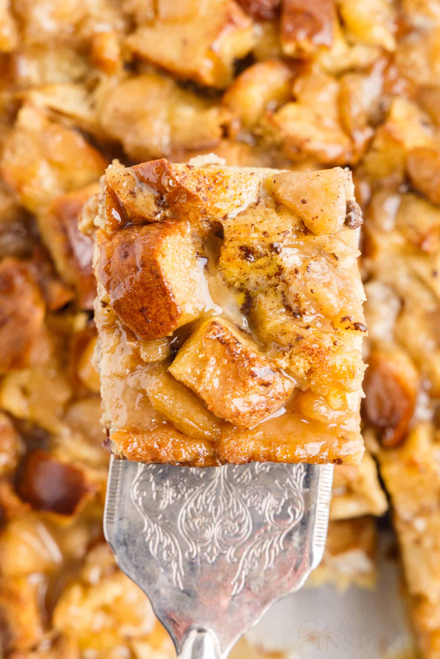 close up of a slice of apple bread pudding with caramel sauce on top