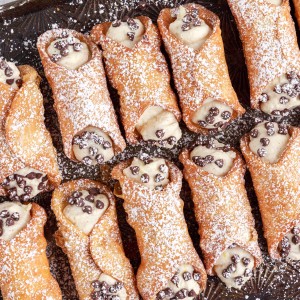 homemade cannoli on a baking sheet with chocolate chips