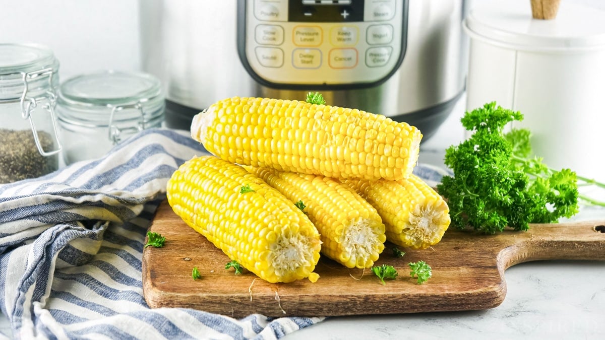 Fours ears of instant pot corn on the cob on a cutting board.