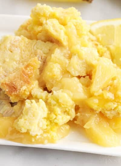 Close up of lemon pineapple dump cake with a lemon wheel on the side.