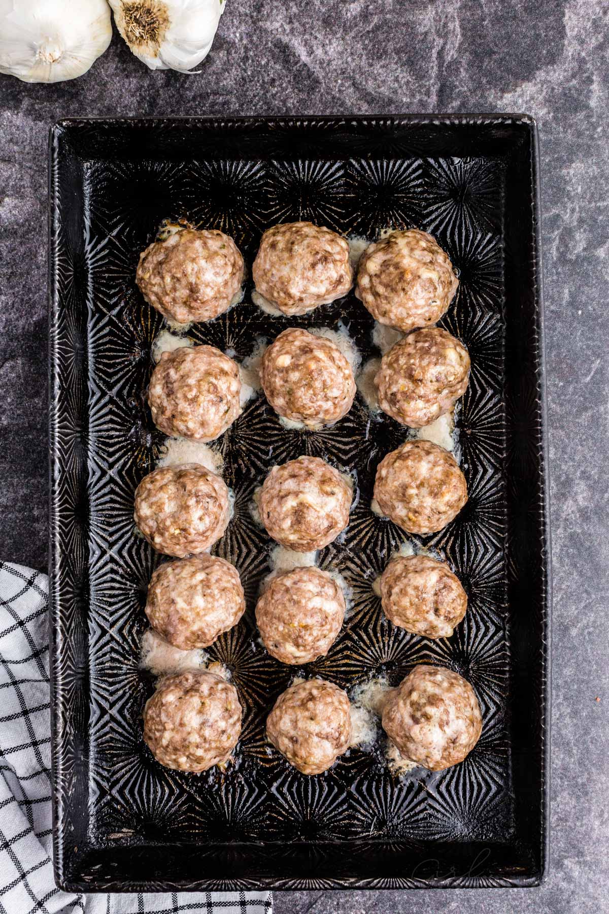 a baking sheet full of oven baked meatballs.