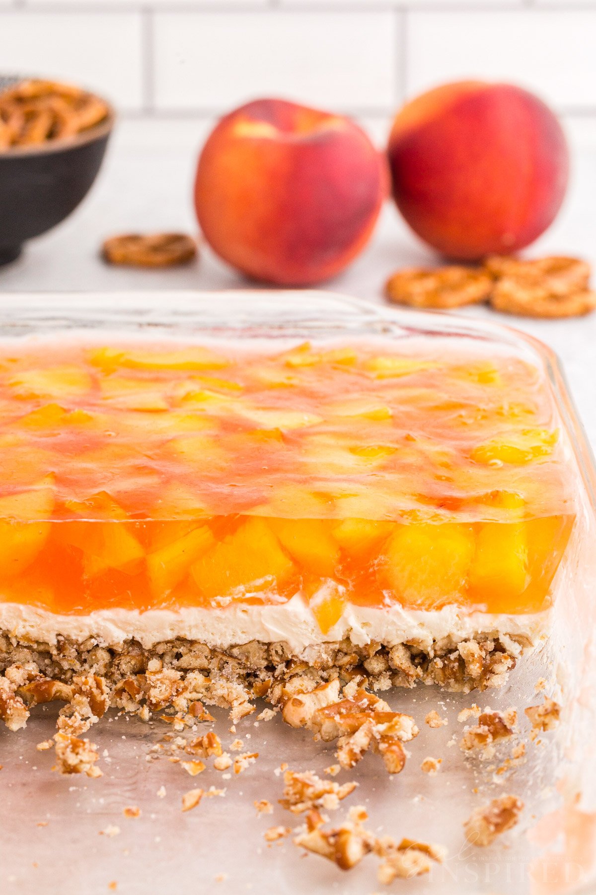 Side view of the peach pretzel salad showing the three layers: pretzel crust, creamy middle, and peach jello.