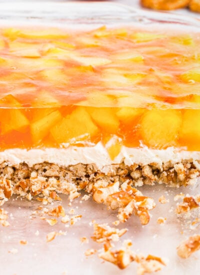 Side view of the peach pretzel salad showing the three layers: pretzel crust, creamy middle, and peach jello.