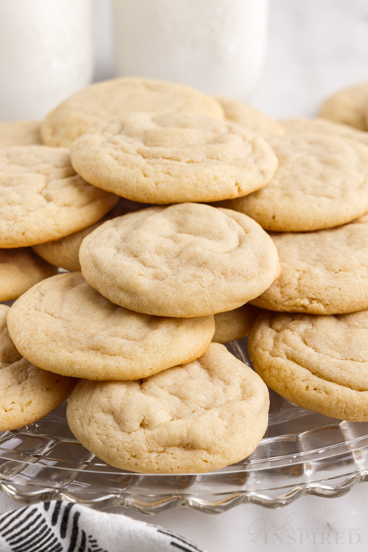 side view of soft and chewy sugar cookies on a glass platter
